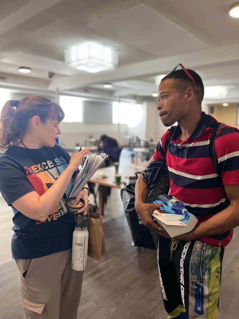 ComFe Team leader issuing bus passes to guest.