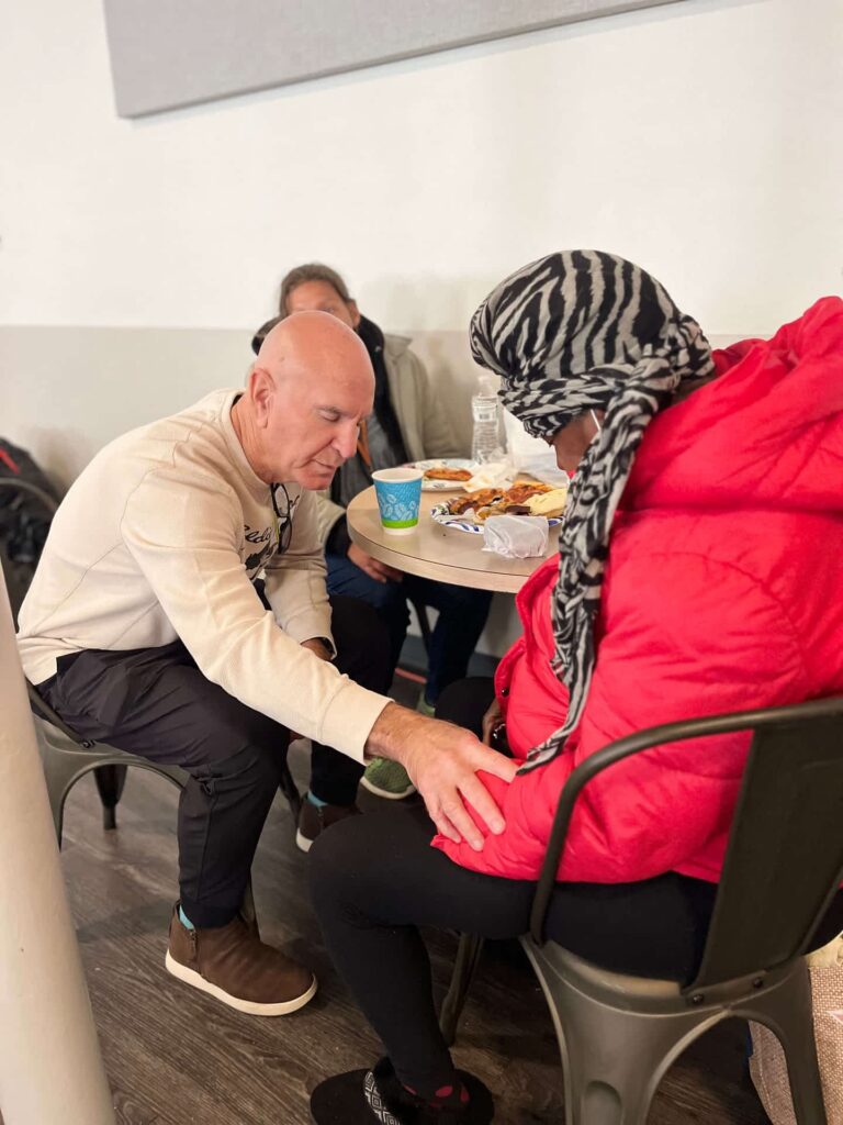 ComFe Team member offering prayer to guest-ComFe