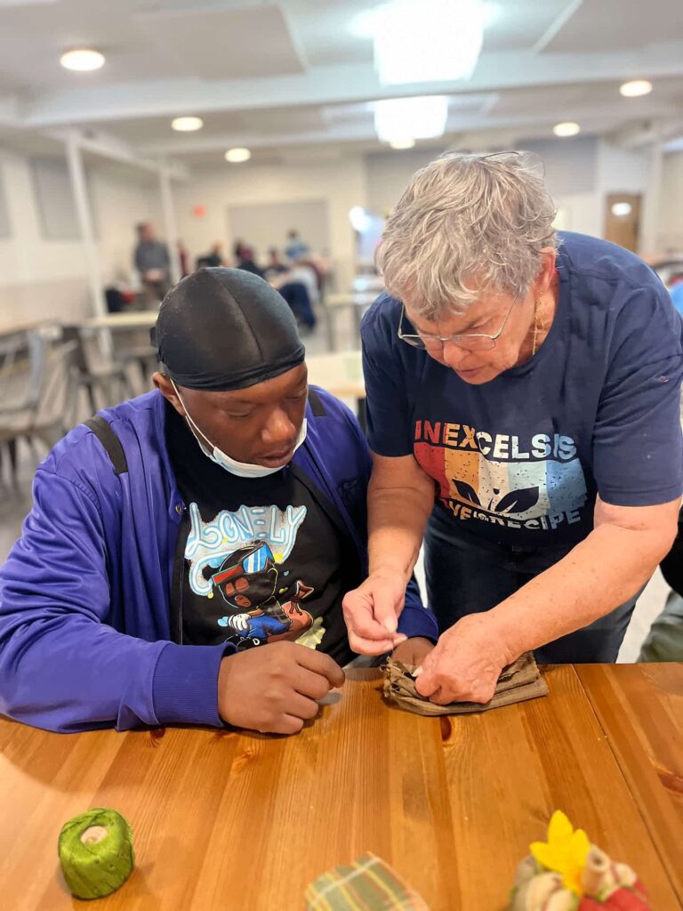 Kathy working personally with a guest during craft workshop.