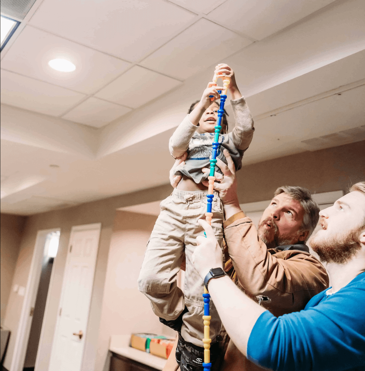 Volunteers playing with a boy sheltered with his family during Winter Safe Haven @amyelizabethphotographs.