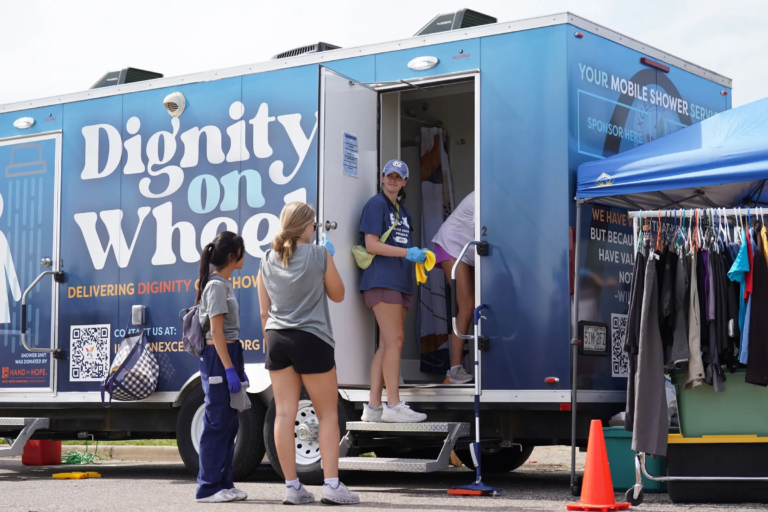 3 volunteers cleaning and preparing the shower trailer for an event.