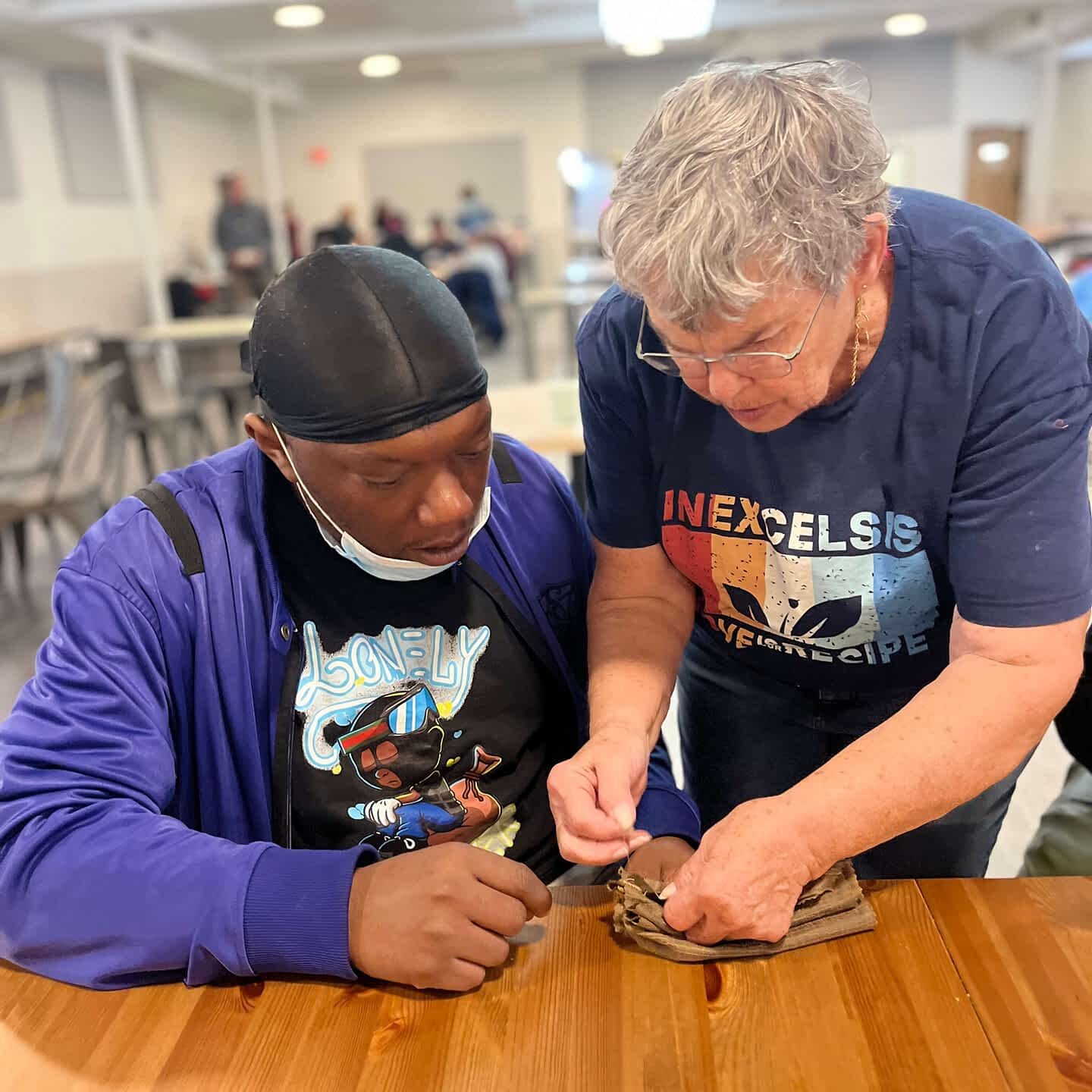 Kathy working personally with a guest during craft workshop. This photo captures one-on-one relational presence, which is core to ComFe's identity.