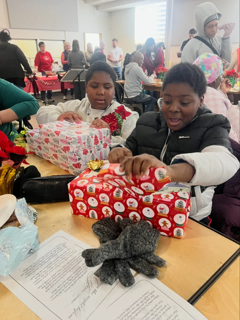 Guest's grandchildren ecstatic opening their Christmas gifts received through Joy To The Lou.