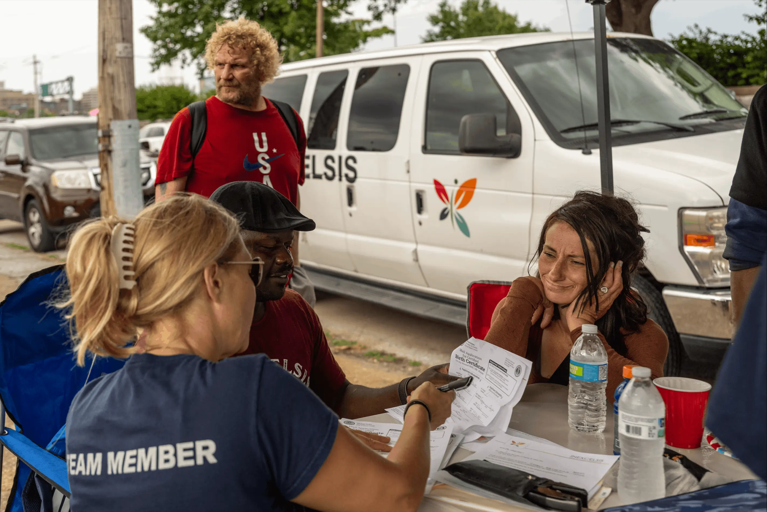 inexcelsis volunteers assisting a guest applying for a birth certificate at the field of dreams encampment.